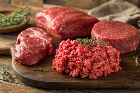 Raw beef mince and cuts on a butcher board, a lean protein source for a dog's raw diet